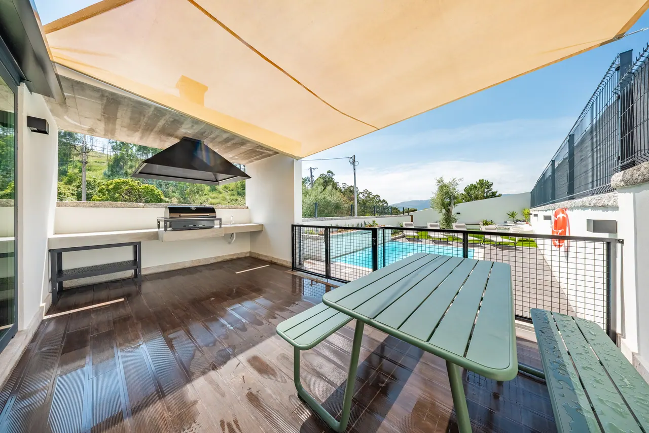Pérgola com mesa de piquenique junto à piscina