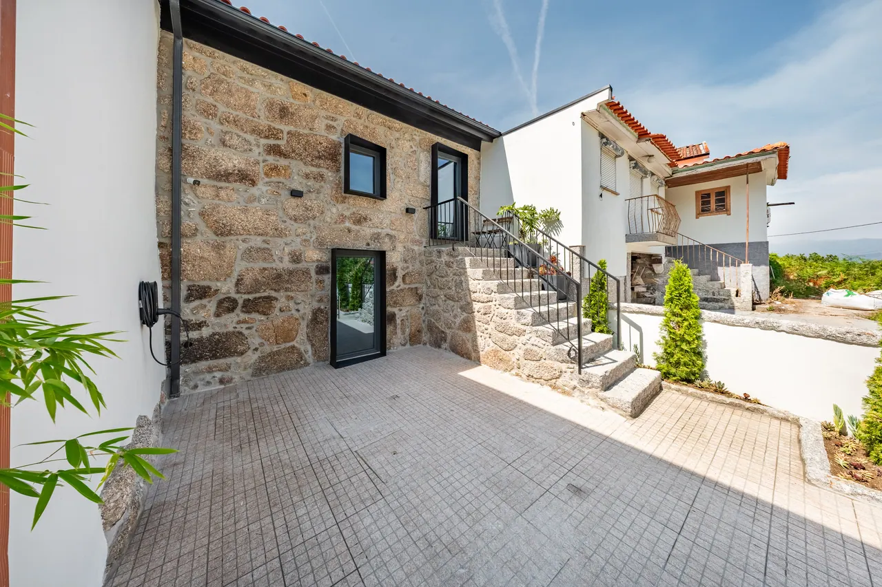 Entrada em pedra com escadas de acesso à casa