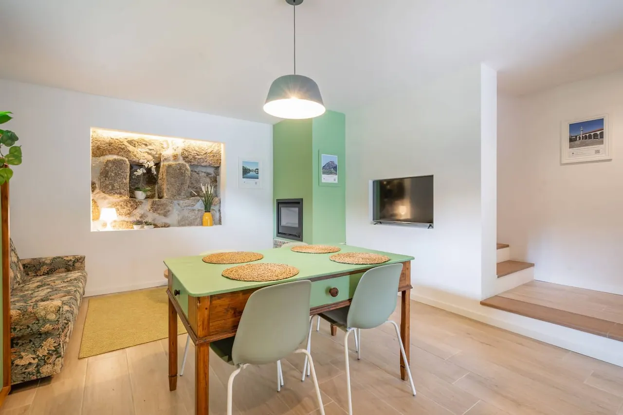 Sala de refeições em open space com cozinha verde ao fundo